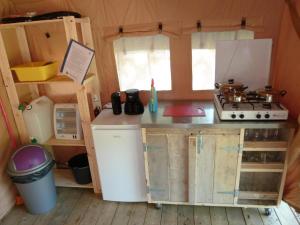 een kleine keuken in een tiny house met een fornuis bij Safaritent op groen en kindvriendelijk park op de Veluwe in Epe