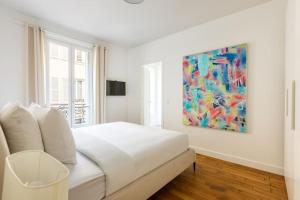 Un dormitorio con una cama blanca y una pintura en la pared en Invalides - Rénové - Luxe, en París