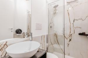 a white bathroom with a sink and a shower at Casa Roma B&B in Rome +32 photos