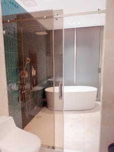 uma casa de banho com uma banheira, um chuveiro e um WC. em Malloire House Hue em Hue