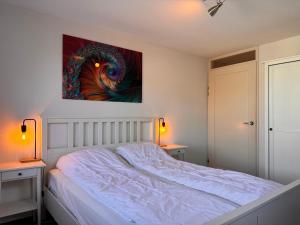 ein Schlafzimmer mit einem Bett und einem Gemälde an der Wand in der Unterkunft Callantsoger Staete 210 in Callantsoog