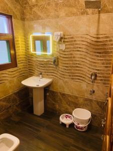 ein Badezimmer mit einem Waschbecken, einem WC und einem Spiegel in der Unterkunft Faizzy's residency in Srinagar