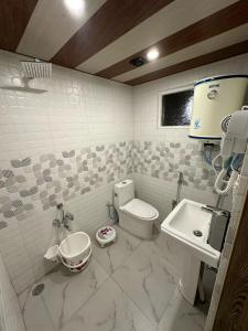 y baño con aseo y lavamanos. en Faizzy's residency, en Srinagar