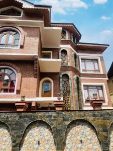 un gran edificio de ladrillo con ventanas en la parte superior en Faizzy's residency en Srinagar