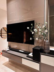 順化的住宿－Malloire House Hue，客厅里的一个大电视,花卉