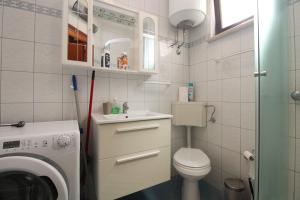 a bathroom with a washing machine and a washer at Apartments Richard 2319 in Pješčana Uvala  +51 photos
