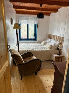 ein Schlafzimmer mit einem Bett, einem Stuhl und einem Fenster in der Unterkunft Zdzisiówka in Walim