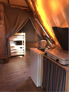 Tienda de campaña con cocina con nevera y fogones. en Camping Le Bois De Pins, en Salses-le-Chateau
