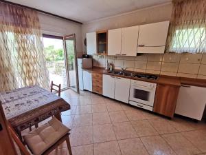 a kitchen with white cabinets and a table and a table and a table at Nettes Appartement in Crikvenica mit Terrasse in Crikvenica