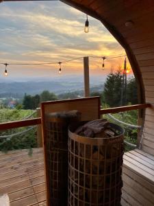 a trash can on a deck with a view of the sunset at Osada Na Ochodzitej in Koniaków