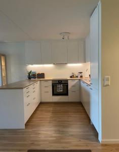 a white kitchen with white cabinets and a stove at Great 2 bedroom apartment in Tromsø centrum! in Tromsø