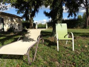 two chairs sitting in the grass in front of a house at Logement charme provençal in Cabannes