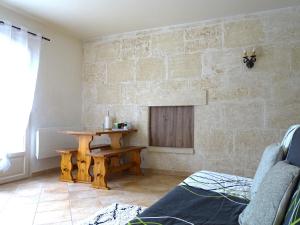 salon ze stołem i kamienną ścianą w obiekcie Logement charme provençal w mieście Cabannes