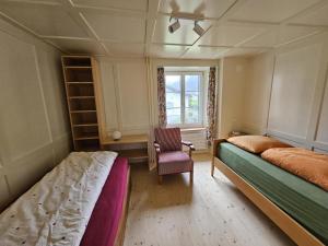 1 Schlafzimmer mit 2 Betten, einem Stuhl und einem Fenster in der Unterkunft Revier z'Uhrmachers in Rüti