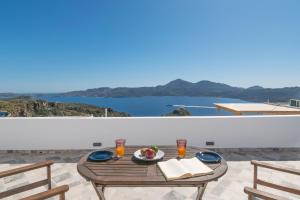a table on a balcony with a view of the ocean at Noula House & Studios in Plaka Milou