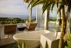 a bath tub on a balcony with a view of the ocean at Villa Puri Soka in Pabean Buleleng