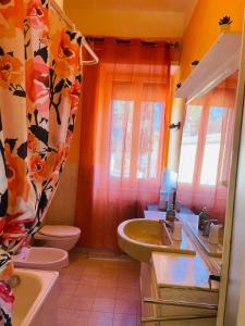 een badkamer met een wastafel, een toilet en een bad bij Maremma Nel Tufo Centro in Pitigliano
