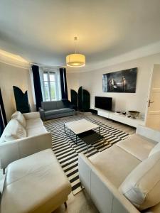 een woonkamer met witte banken en een tv bij Luxury apartment Times Square district in Parijs