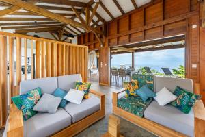 a living room with two couches and a table at Calypso Bay in Bouillante