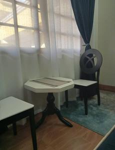 a table and a chair in a room with a window at Riverside Apartments in Buwate