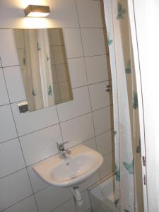 ein Bad mit einem Waschbecken und einem Spiegel in der Unterkunft Ośrodek Wczasowy Akacja in Dźwirzyno