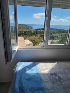 a bedroom with a window with a view of the ocean at Lux apartmani Anastasija in Sutomore