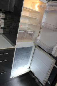 an empty refrigerator with its door open in a kitchen at Coqueta casita en Tetuán in Madrid