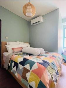 1 dormitorio con 1 cama con una manta colorida en Luxury 2 BR Trans Studio Cibubur, en Kalimanggis