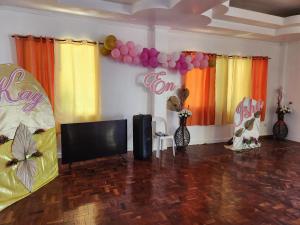 a room with a flat screen tv and balloons at Twin Island Beach House in Hinunangan