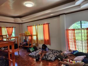 Hinunangan的住宿－Twin Island Beach House，一群人坐在房间里的床边