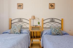 two beds sitting next to each other in a bedroom at Smart La Barrosa in Novo Sancti Petri
