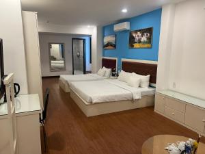 1 dormitorio con 2 camas y pared azul en A25 Hotel - 274 Đề Thám en Ho Chi Minh