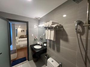 a bathroom with a sink and a toilet and a mirror at A25 Hotel - 274 Đề Thám in Ho Chi Minh City