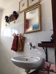 y baño con lavabo y espejo. en Blue House Apartman Kék Ház Üdülő, en Dunapataj