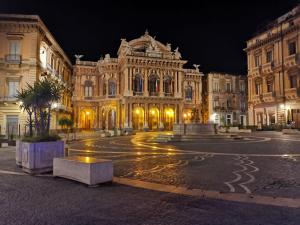 a large building at night with lights on the street at Fuoco dell'Etna in Catania +55 photos