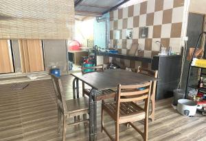 eine Küche mit einem Tisch und Stühlen im Zimmer in der Unterkunft OYO 90971 Pollock Homestay in Sungai Lembing