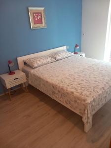 - une chambre avec un lit et un mur bleu dans l'établissement Nina, à Pula