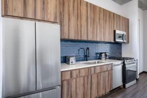 una cucina con armadi in legno e frigorifero in acciaio inossidabile di Blueground West Loop rooftop dog wash nr L CHI-1055 a Chicago