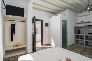 a bedroom with a bed and a tv on the wall at Noula House & Studios in Plaka Milou