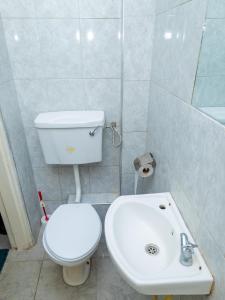 ein Badezimmer mit einem weißen WC und einem Waschbecken in der Unterkunft Cherry Home Stays KE in Nairobi