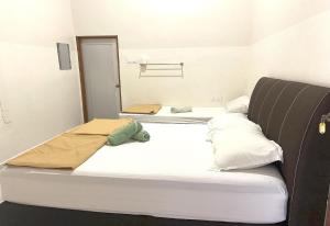 duas camas num quarto com uma estratégia de estratégias de não discriminação em OYO 90971 Pollock Homestay em Sungai Lembing