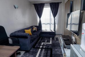 ein Wohnzimmer mit einem Sofa und einem Fenster in der Unterkunft Cherry Home Stays KE in Nairobi