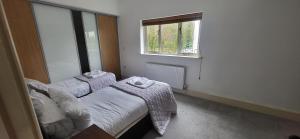 Cette petite chambre comprend 2 lits et une fenêtre. dans l'établissement Woodlands, à Windermere