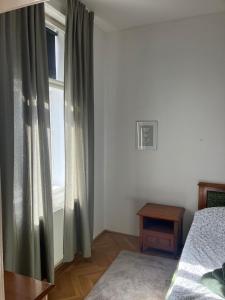 1 dormitorio con 1 cama y una ventana con cortinas en Ruhige Wohnung in Helenental, en Baden