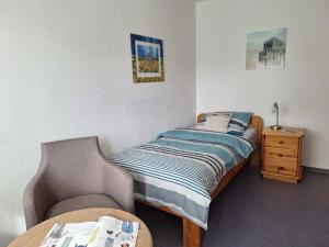 a small bedroom with a bed and a chair at Haus Petra - Fewo 1 in Dahme