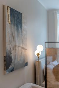 ein Schlafzimmer mit einem Gemälde an der Wand und einer Lampe in der Unterkunft Ludwig Apartment I levestate in Wien