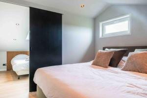 a bedroom with a large bed with a black wall at Casa Fico, luxe huisje met hottub én kamado in Kapelle