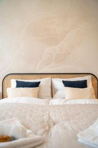 Bett mit weißer Bettwäsche und blauen Kissen in der Unterkunft Ludwig Apartment I levestate in Wien