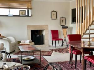 - un salon avec des chaises rouges et une cheminée dans l'établissement Maison - Mer Calme - by Melrose, à Port-en-Bessin-Huppain