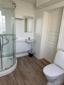 uma casa de banho com um chuveiro, um WC e um lavatório. em Tune Hotell Sarpsborg em Sarpsborg